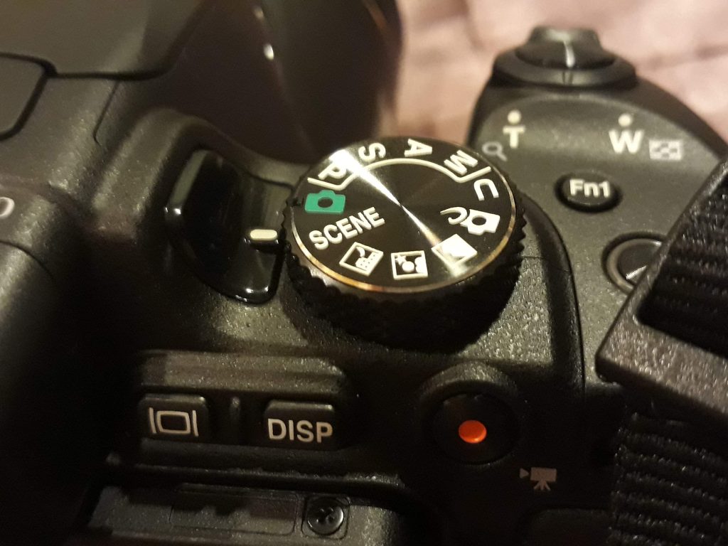 A picture for my Nikon B700 review that shows the camera's dial and modes. 